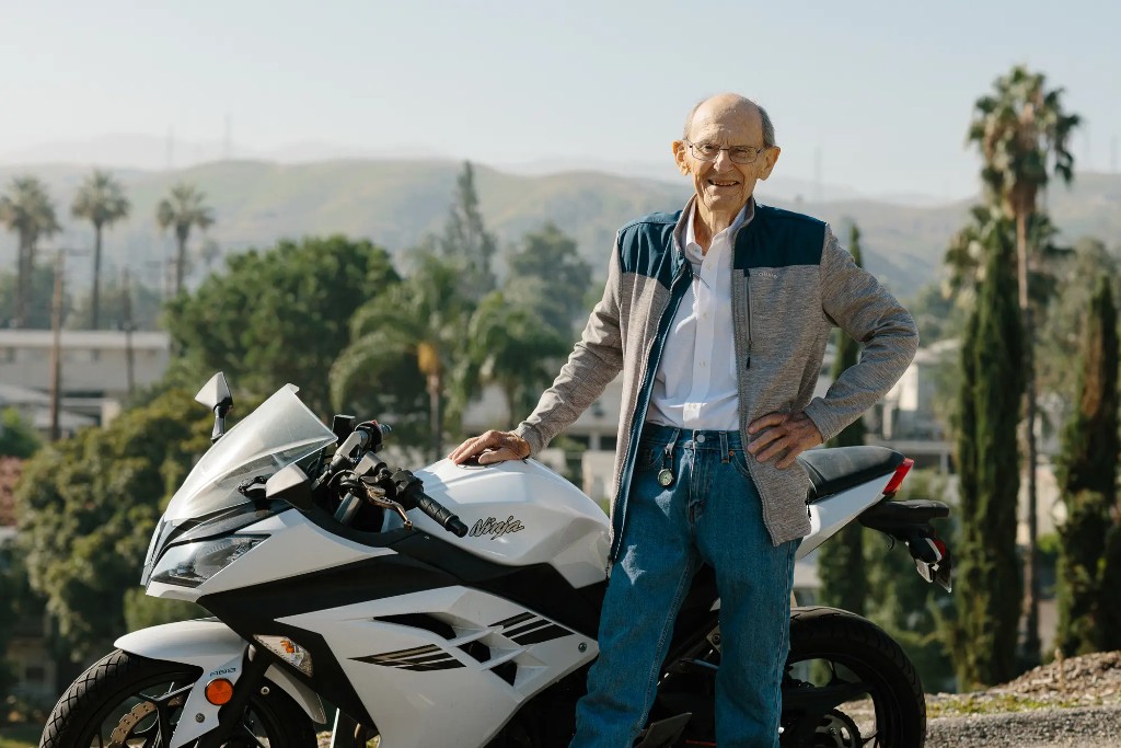 David J. Baylink standing beside his white Kawasaki Ninja in the hills above Loma Linda, California