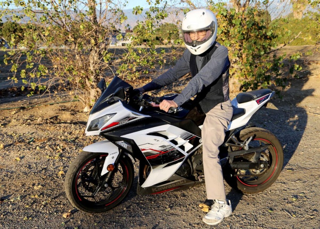 David Baylink in helmet and riding gear, seated on his Kawasaki Ninja at golden hour